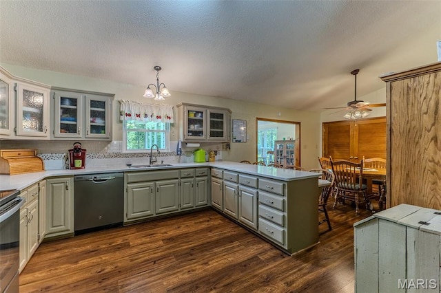 kitchen with appliances with stainless steel finishes, gray cabinetry, a peninsula, dark wood-style floors, and glass insert cabinets