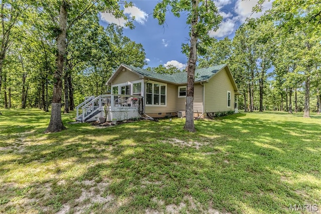 view of front of home with crawl space, a front yard, a deck, a shingled roof, and stairs