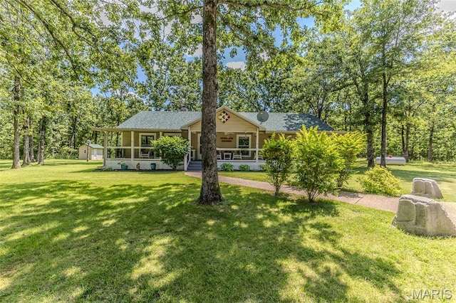 view of front of property featuring covered porch, a front lawn, and a shingled roof