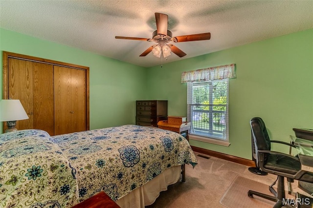 bedroom with carpet flooring, a closet, ceiling fan, and a textured ceiling