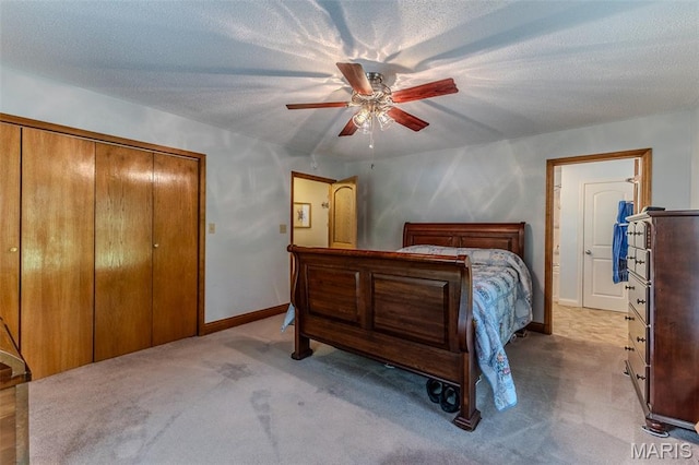 carpeted bedroom with ceiling fan, a textured ceiling, and a closet