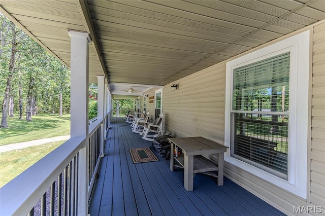 wooden porch featuring a lawn