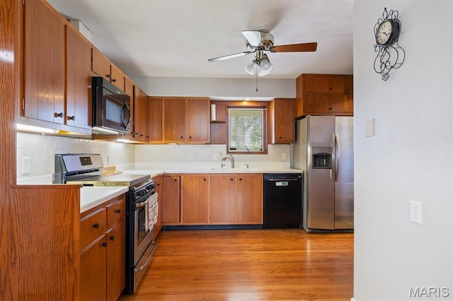 65 Harmon Dr, Lebanon, IL 62254 - kitchen with black appliances, a ceiling fan, light countertops, light wood-style flooring, and tasteful backsplash