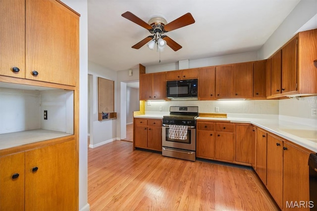 65 Harmon Dr, Lebanon, IL 62254 - kitchen with black appliances, light wood-style flooring, a ceiling fan, light countertops, and brown cabinets