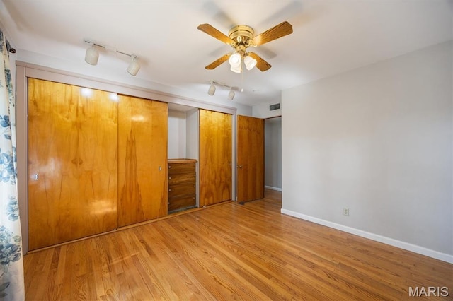 65 Harmon Dr, Lebanon, IL 62254 - unfurnished bedroom with wood finished floors, a closet, track lighting, and a ceiling fan