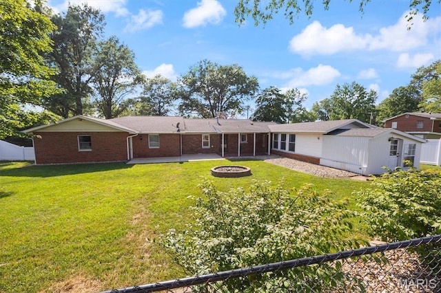 65 Harmon Dr, Lebanon, IL 62254 - back of property with a patio, brick siding, a fire pit, and an outdoor structure
