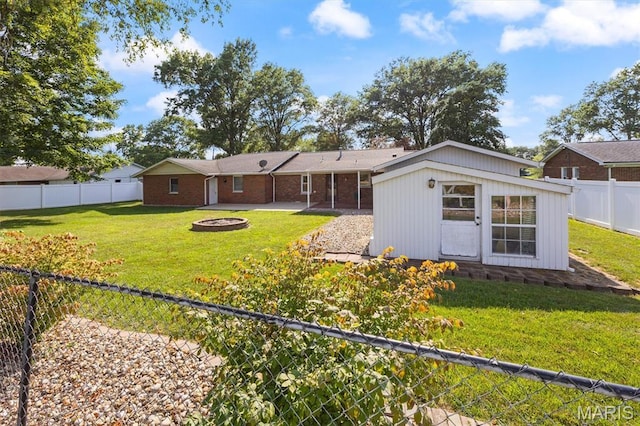 65 Harmon Dr, Lebanon, IL 62254 - rear view of property with an outdoor fire pit, a fenced backyard, and an outdoor structure