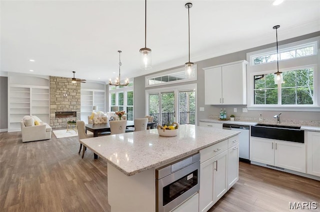 10 Schaper Farms Ct, Foristell, MO 63348 - kitchen featuring stainless steel appliances, plenty of natural light, a fireplace, wood finished floors, and recessed lighting