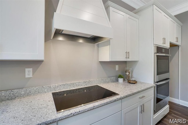10 Schaper Farms Ct, Foristell, MO 63348 - kitchen with custom exhaust hood, black electric stovetop, stainless steel double oven, and white cabinetry