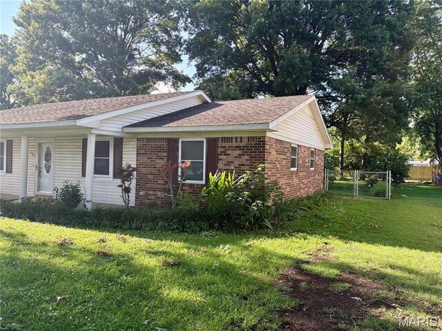 305 Manor, Steele, MO 63877 - view of home's exterior with a gate, brick siding, and a shingled roof