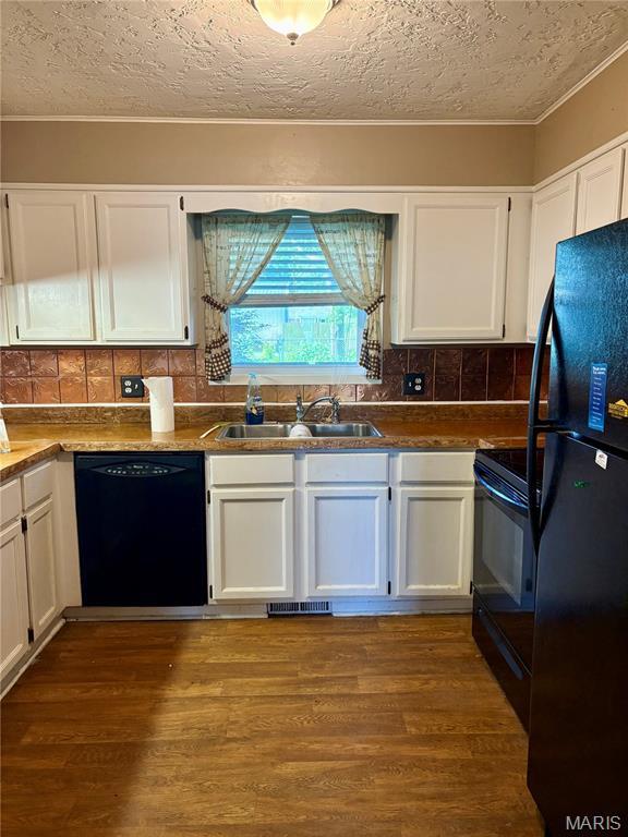 305 Manor, Steele, MO 63877 - kitchen featuring black appliances, white cabinetry, a textured ceiling, backsplash, and dark wood finished floors