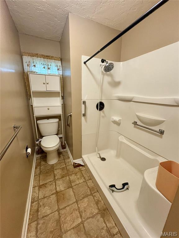 305 Manor, Steele, MO 63877 - full bath with a textured ceiling, a stall shower, and stone finish floors