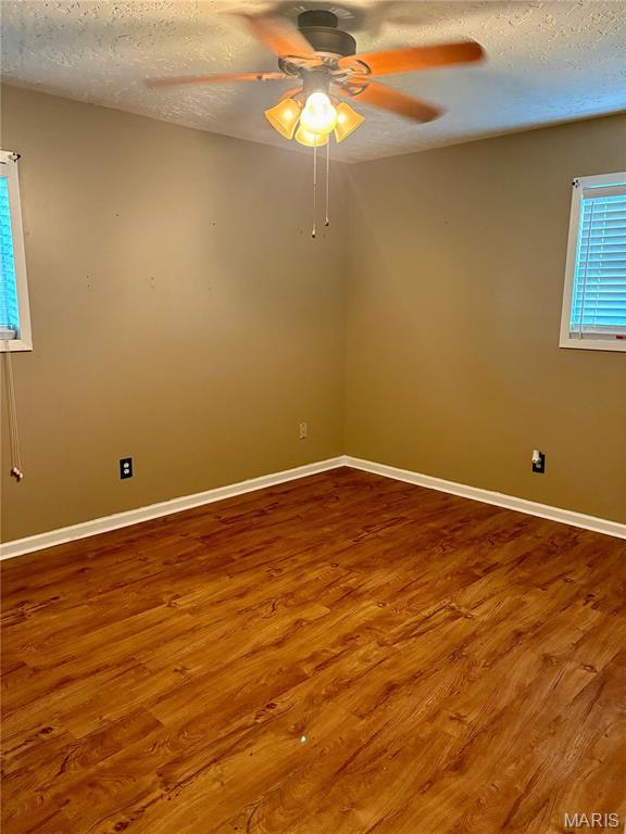 305 Manor, Steele, MO 63877 - empty room featuring a textured ceiling, wood finished floors, and ceiling fan