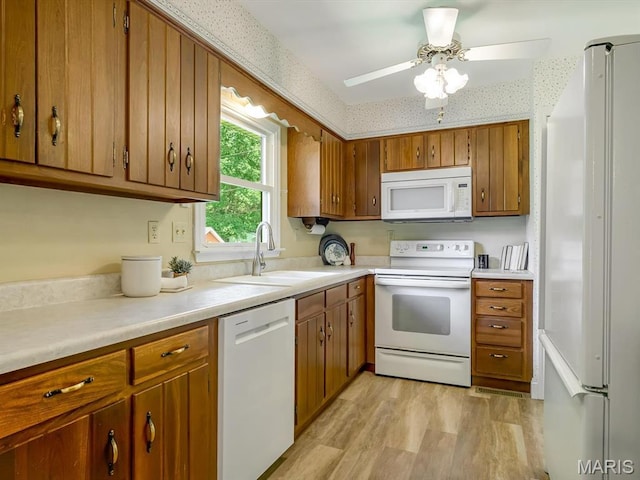 1471 Ladd Ave, Edwardsville, IL 62025 - kitchen with white appliances, brown cabinets, light countertops, light wood finished floors, and wallpapered walls