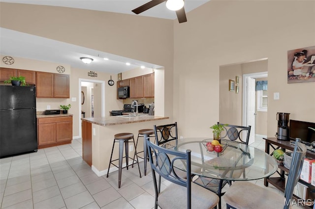 22 Green Acres Rd, Bellefontaine Nghbrs, MO 63137 - dining room featuring ceiling fan, light tile patterned floors, and a high ceiling