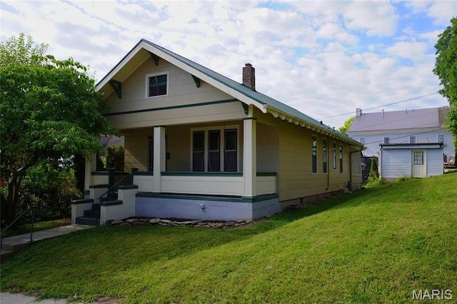 130 E 2nd St, Hermann, MO 65041 - view of front of house with a front yard, a chimney, and covered porch