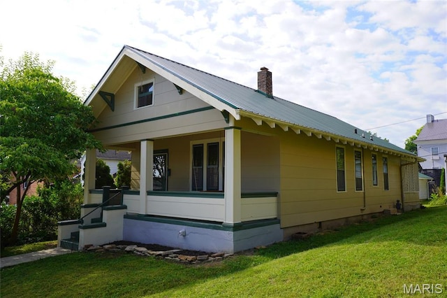 130 E 2nd St, Hermann, MO 65041 - view of side of home with a metal roof, a yard, a porch, and a chimney