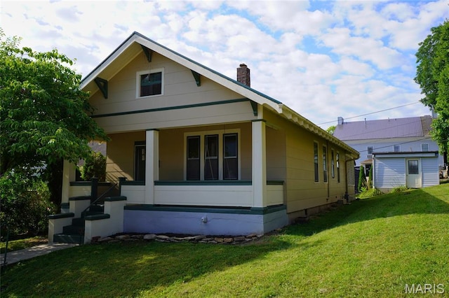 130 E 2nd St, Hermann, MO 65041 - view of front facade with a front lawn, a chimney, and a porch