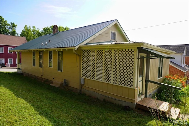 130 E 2nd St, Hermann, MO 65041 - view of side of property with a chimney, a metal roof, and a lawn