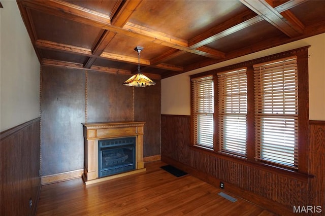130 E 2nd St, Hermann, MO 65041 - unfurnished living room with wood finished floors, coffered ceiling, wooden walls, a wainscoted wall, and a glass covered fireplace