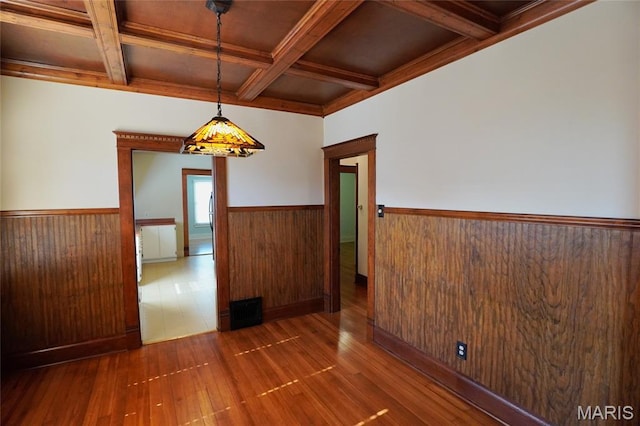 130 E 2nd St, Hermann, MO 65041 - spare room with coffered ceiling, wainscoting, hardwood / wood-style floors, beamed ceiling, and wooden walls