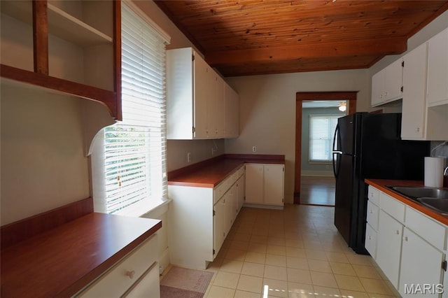 130 E 2nd St, Hermann, MO 65041 - kitchen featuring wood ceiling, light tile patterned flooring, white cabinetry, freestanding refrigerator, and open shelves