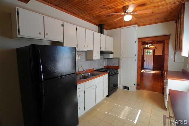 130 E 2nd St, Hermann, MO 65041 - kitchen with black appliances, ceiling fan, wooden ceiling, under cabinet range hood, and backsplash