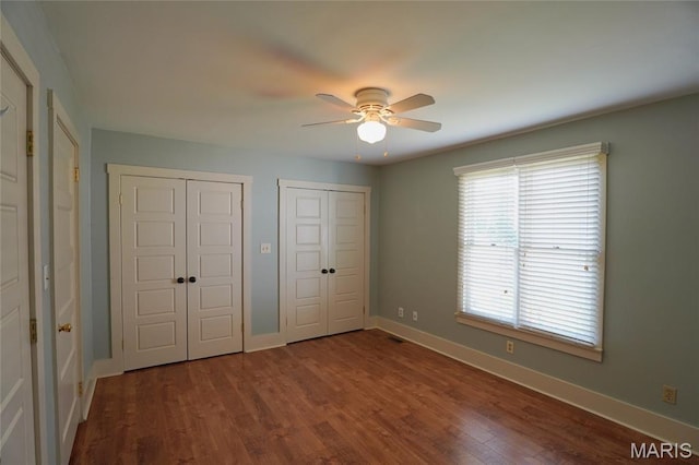 130 E 2nd St, Hermann, MO 65041 - unfurnished bedroom featuring multiple closets, dark wood-style floors, and ceiling fan