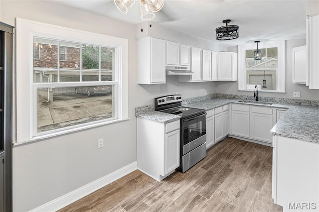 14 S 87th St, Belleville, IL 62223 - kitchen with stainless steel electric range oven, under cabinet range hood, light wood-style floors, and white cabinets