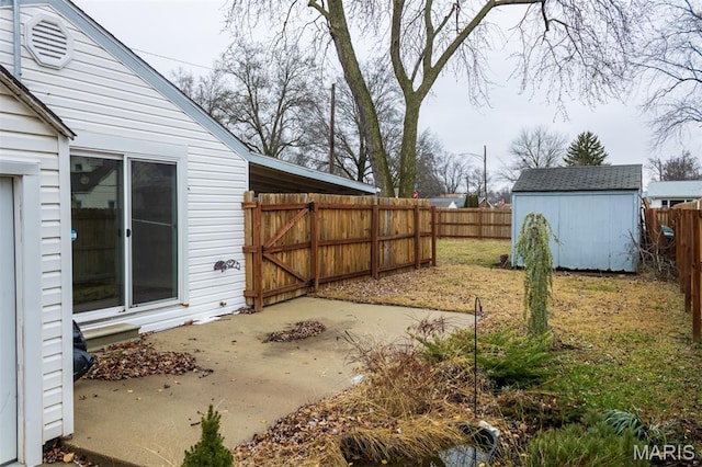 601 E Jefferson St, Ofallon, IL 62269 - fenced backyard featuring a patio, a storage unit, and a gate