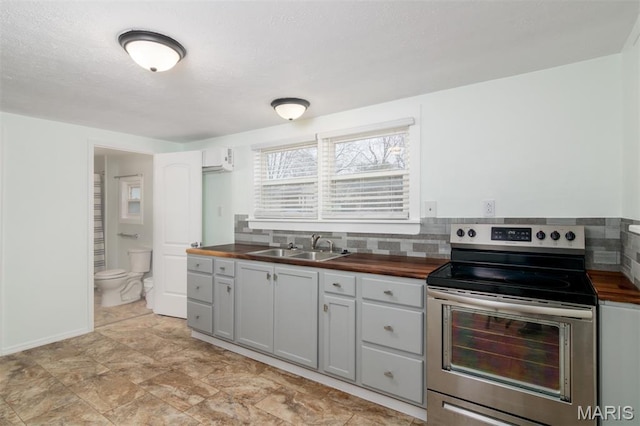 601 E Jefferson St, Ofallon, IL 62269 - kitchen with electric stove, butcher block counters, and decorative backsplash