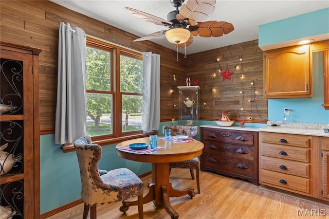 549 E 9th St, Alton, IL 62002 - dining space featuring a ceiling fan, light wood-style flooring, and wooden walls