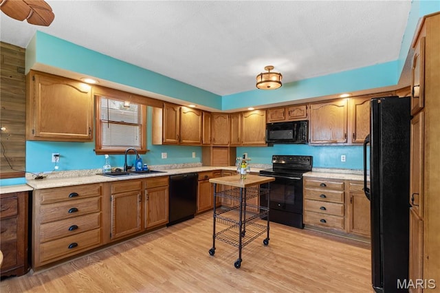 549 E 9th St, Alton, IL 62002 - kitchen featuring black appliances, brown cabinetry, light wood-type flooring, and light countertops