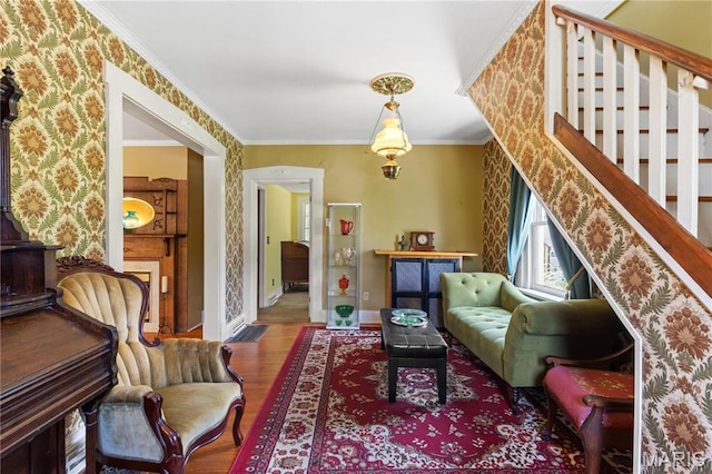 549 E 9th St, Alton, IL 62002 - living area featuring wood finished floors, wallpapered walls, ornamental molding, and stairway