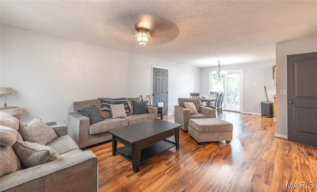 305 Pine Tree Rd, Rolla, MO 65401 - living room featuring wood finished floors, a chandelier, and a textured ceiling