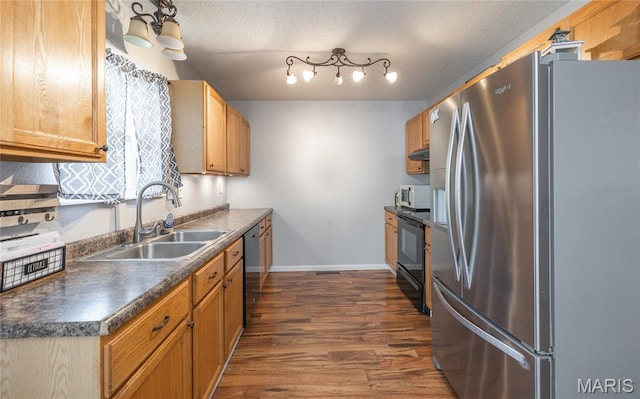 305 Pine Tree Rd, Rolla, MO 65401 - kitchen with appliances with stainless steel finishes, dark countertops, dark wood-type flooring, under cabinet range hood, and a textured ceiling