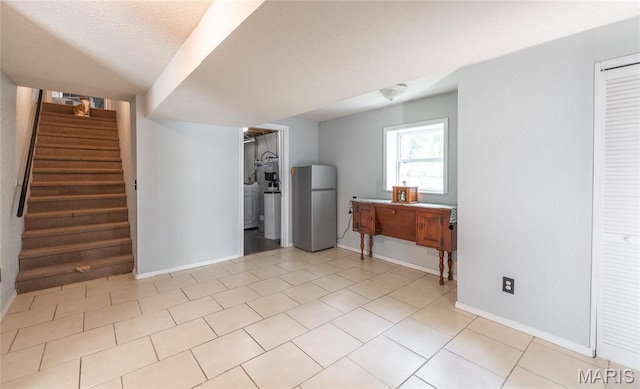 305 Pine Tree Rd, Rolla, MO 65401 - below grade area with freestanding refrigerator, stairs, and light tile patterned floors