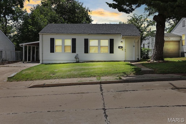345 Mueller Ave, Ferguson, MO 63135 - view of front facade featuring a front lawn, driveway, and a carport