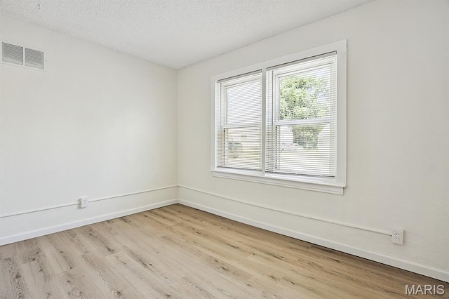 345 Mueller Ave, Ferguson, MO 63135 - spare room featuring wood finished floors and a textured ceiling