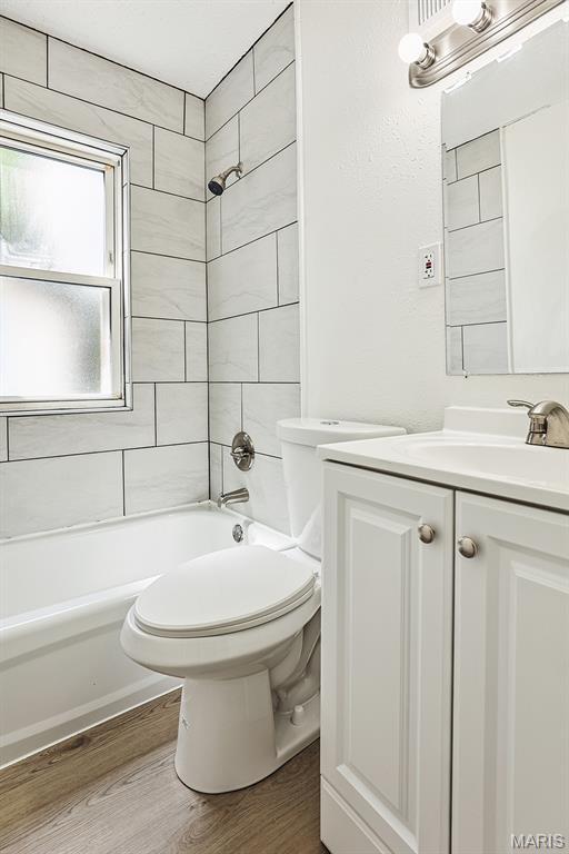 345 Mueller Ave, Ferguson, MO 63135 - full bathroom featuring vanity, wood finished floors, and shower / bathtub combination
