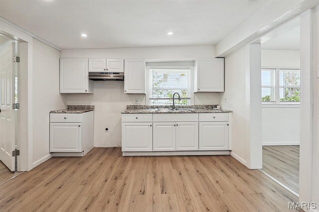 345 Mueller Ave, Ferguson, MO 63135 - kitchen with under cabinet range hood, plenty of natural light, white cabinets, light wood finished floors, and recessed lighting