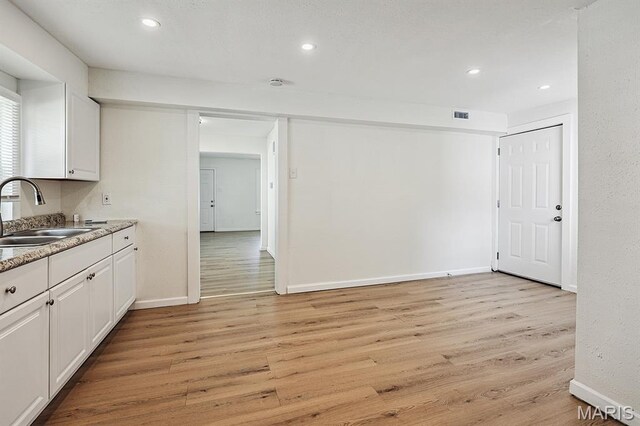 345 Mueller Ave, Ferguson, MO 63135 - kitchen with white cabinets, light wood-style flooring, and recessed lighting