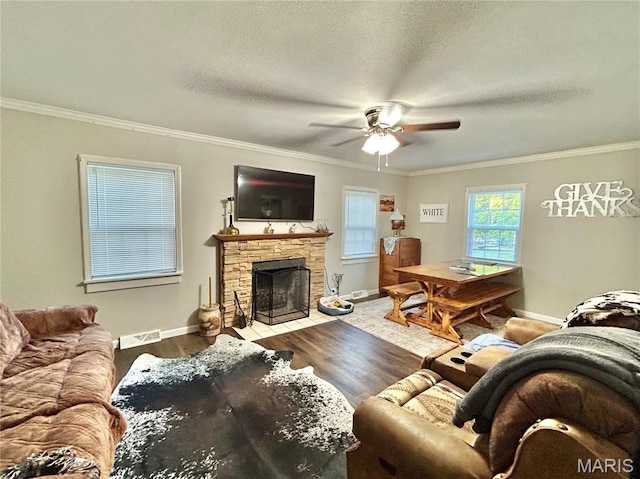 1409 S Washington St, Salem, MO 65560 - living area with crown molding, a stone fireplace, wood finished floors, a ceiling fan, and a textured ceiling