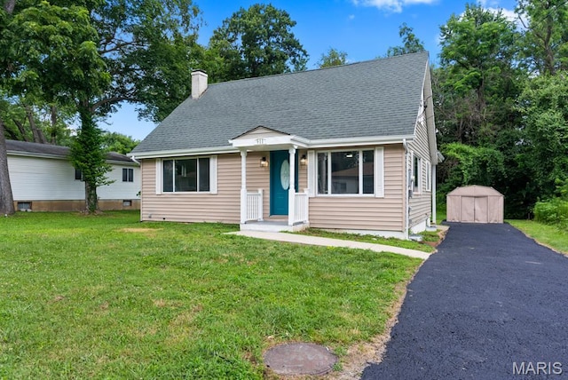 911 Cordova St, Saint Ferdinand Township, MO 63138 - view of front of home with a chimney, a front lawn, a shed, roof with shingles, and driveway