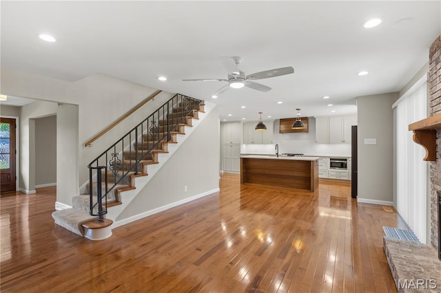 502 Lalor Dr, Manchester, MO 63011 - kitchen with ceiling fan, light countertops, stainless steel microwave, light wood finished floors, and recessed lighting