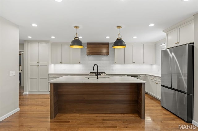 502 Lalor Dr, Manchester, MO 63011 - kitchen with freestanding refrigerator, custom exhaust hood, light countertops, tasteful backsplash, and light wood-style floors