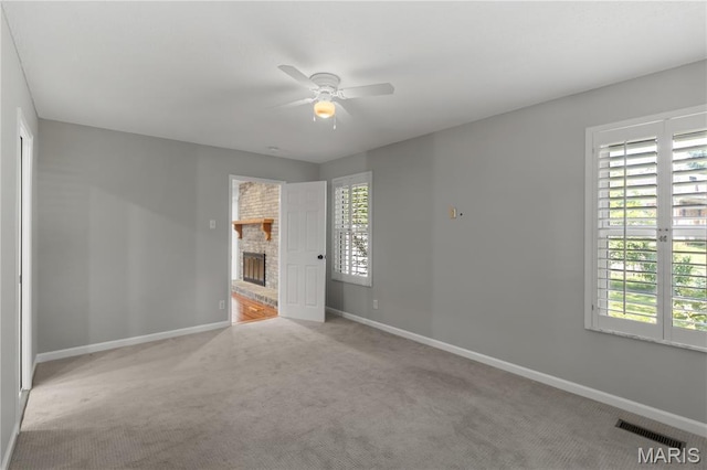 502 Lalor Dr, Manchester, MO 63011 - carpeted empty room with a ceiling fan and a brick fireplace