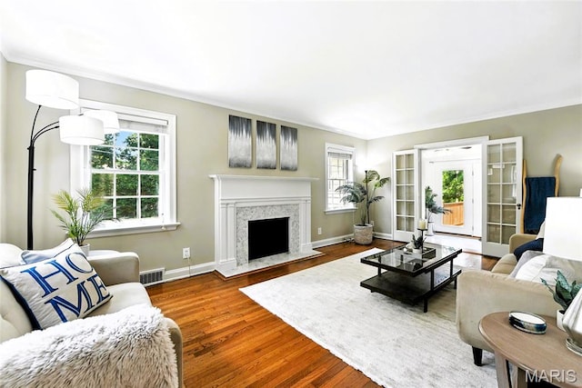 8049 Gannon Ave, Saint Louis, MO 63130 - living room featuring plenty of natural light, crown molding, wood finished floors, and a high end fireplace
