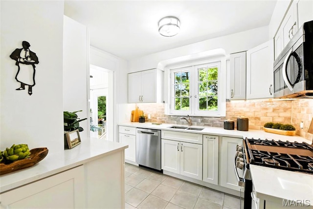 8049 Gannon Ave, Saint Louis, MO 63130 - kitchen with stainless steel appliances, light tile patterned flooring, plenty of natural light, and decorative backsplash