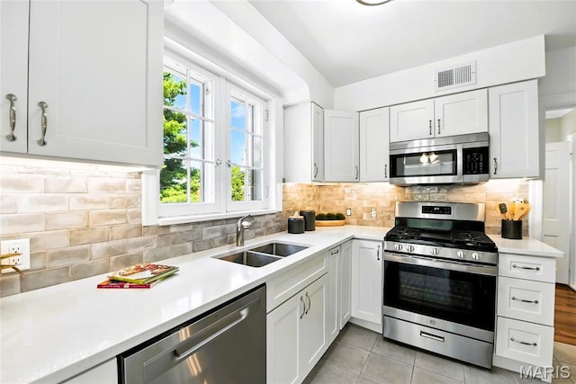 8049 Gannon Ave, Saint Louis, MO 63130 - kitchen featuring appliances with stainless steel finishes, light countertops, and white cabinets